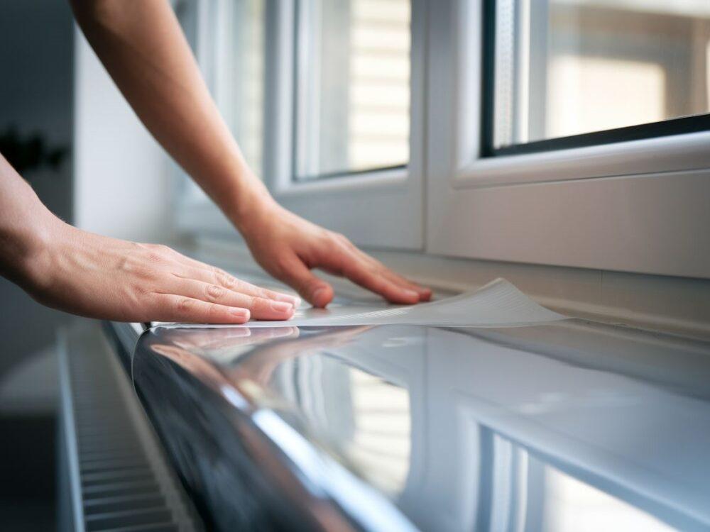 0Użycie rakli do wygładzania okleiny na powierzchni parapetu