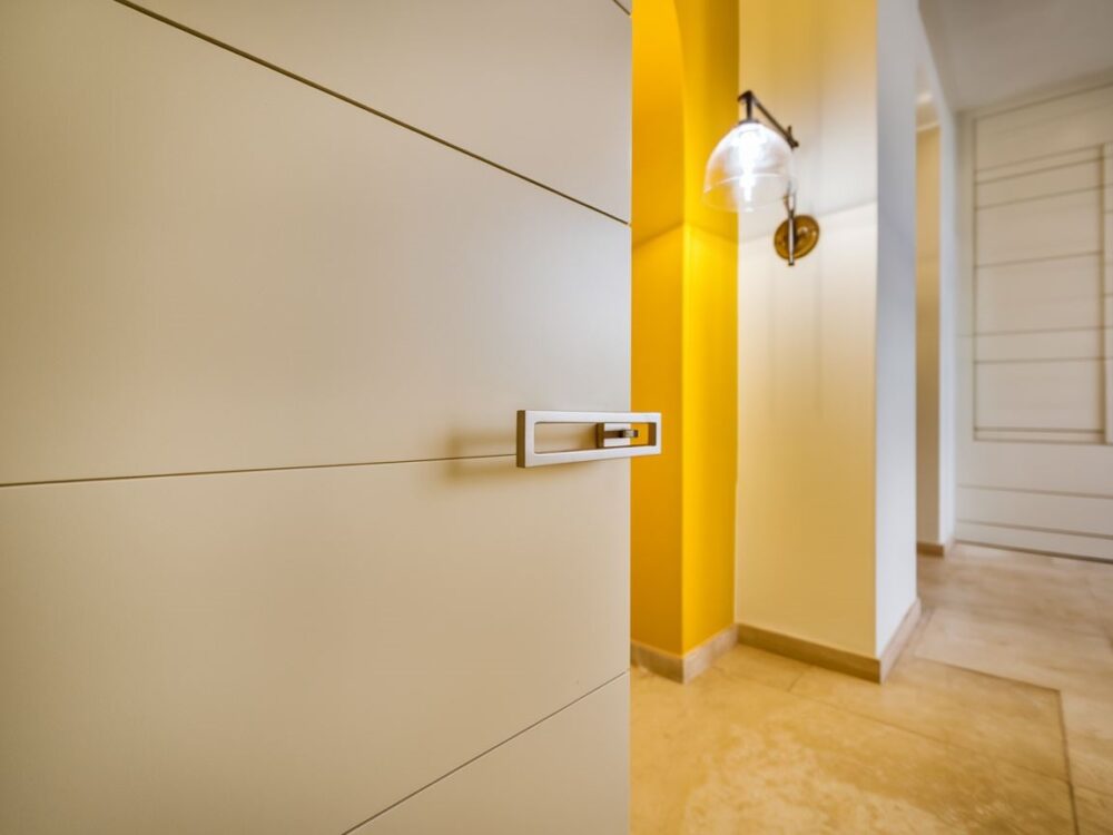 Nowoczesna klamka dopasowana do białych drzwi